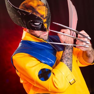 May include: A person dressed as Wolverine, a comic book superhero, wearing a yellow and blue costume with a black mask and claws.