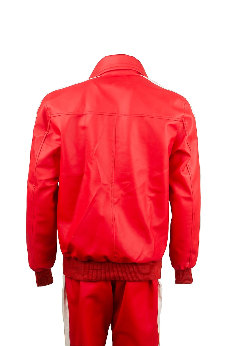 May include: Red track suit with white stripes on the sleeves and legs. The jacket has a ribbed collar and cuffs. The back of the jacket is visible, showing the seams and the white stripe detail.