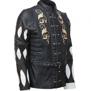 May include: A black leather jacket with a white and black patterned design on the sleeves. The jacket has a high collar, a belt, and gold embroidery on the front.