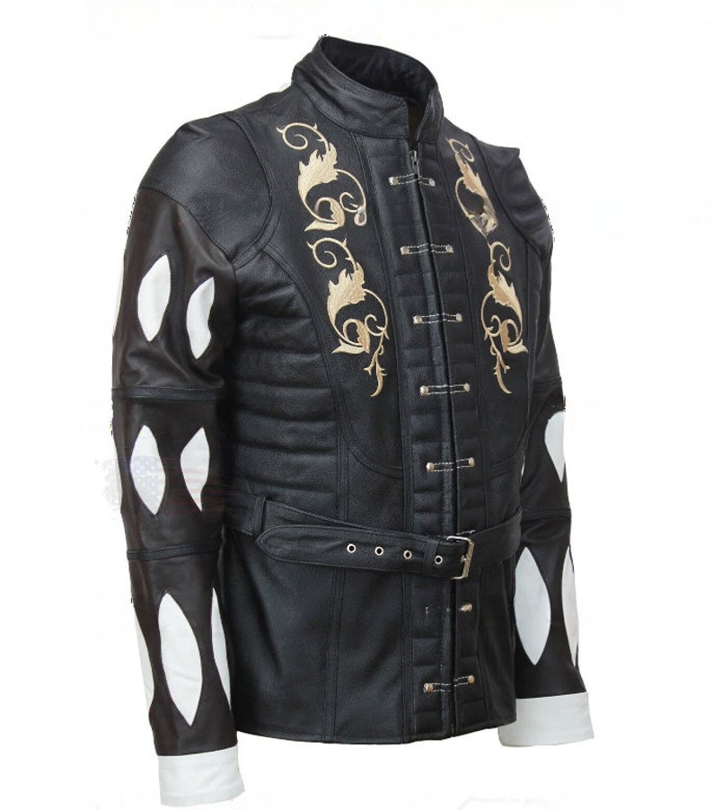May include: A black leather jacket with a white and black patterned design on the sleeves. The jacket has a high collar, a belt, and gold embroidery on the front.