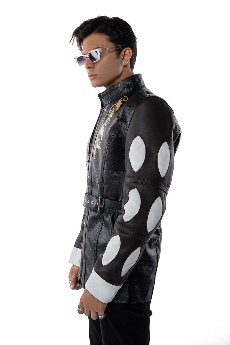 May include: A black leather jacket with white and brown accents. The jacket has a gold embroidered design on the front and a belt at the waist.