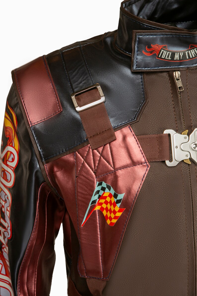 Puede incluir: Una chaqueta de cuero marr&oacute;n con un dise&ntilde;o de carreras rojo y negro. La chaqueta tiene una cremallera, un cuello y un parche de bandera a cuadros en el lado izquierdo. El texto "Fuel My Fire" est&aacute; impreso en la parte posterior de la chaqueta.