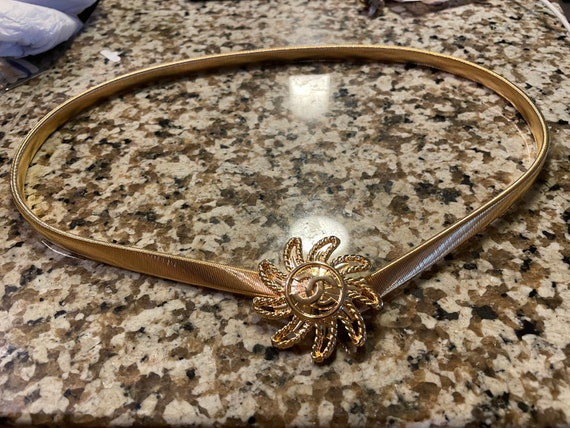 Gold toned sunburst letter stretch belt