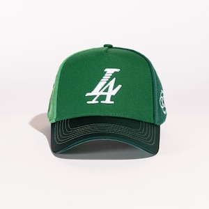 May include: A green and black baseball cap with a white "LA" logo embroidered on the front.