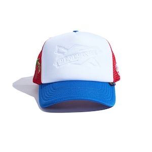 May include: A white, red and blue trucker hat with a white "REFERENCE" logo on the front. The hat has a mesh back and a curved brim.