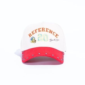 May include: White baseball cap with a red brim, featuring the word "REFERENCE" in orange, the number "20" in blue and yellow, and a football helmet graphic. The brim has silver grommets and the text "Born to Win".