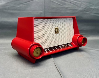 May include: A red vintage Motorola AM radio with a white speaker grille and a chrome dial with numbers 5 through 16. The radio has two chrome knobs on the sides.