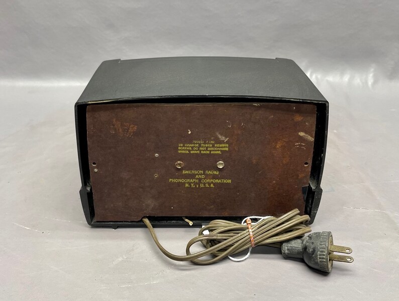 May include: Black and brown vintage Emerson Radio and Phonograph Corporation record player with a power cord and plug.
