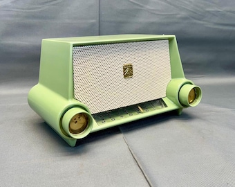 May include: A vintage green and white radio with a metal grill and a gold knob. The radio has a  "MOTOROLA" label on the front.