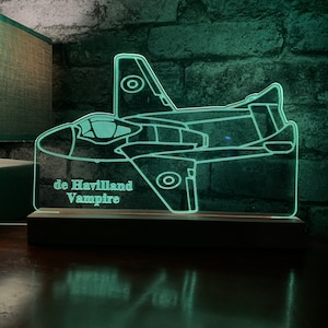 May include: A green acrylic light-up sign with a silhouette of a de Havilland Vampire jet. The sign has the text "de Havilland Vampire" on the bottom.