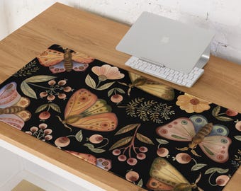 Peut inclure: Un tapis de bureau noir avec un motif aquarelle de papillons, de fleurs et de baies. Les papillons ont des ailes orange, roses et bleues. Le tapis est rectangulaire et repose sur un bureau en bois, avec un ordinateur portable et un clavier.