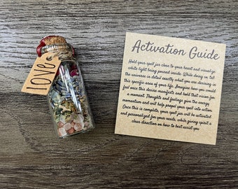 Puede incluir: Una pequeña botella de vidrio con un tapón de corcho y una etiqueta de papel marrón que dice "LOVE". La botella está llena de hierbas secas, flores y cristales. Una tarjeta marrón con el texto "Activation Guide" está al lado de la botella. La tarjeta proporciona instrucciones sobre cómo activar el frasco de hechizos.
