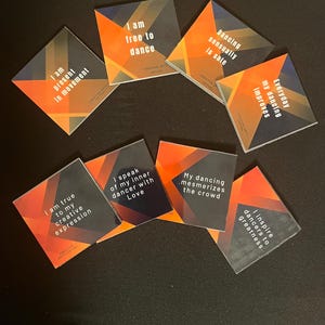 May include: Eight colorful square cards with inspirational quotes about dance. The cards have a black background with orange, yellow, and red geometric shapes. The text on the cards is in white.