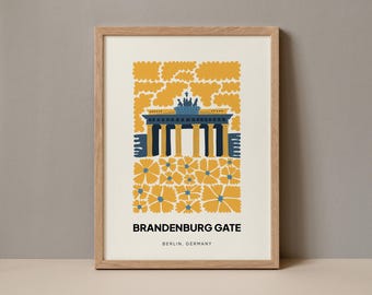 May include: A framed print of a stylized illustration of the Brandenburg Gate in Berlin, Germany. The gate is depicted in blue and white, surrounded by yellow flowers. The text "BRANDENBURG GATE" and "BERLIN, GERMANY" is printed below the illustration.