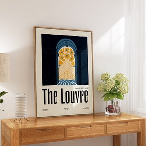 May include: A framed poster with a vintage design featuring a blue and yellow archway with the text "The Louvre" and "Paris, France".