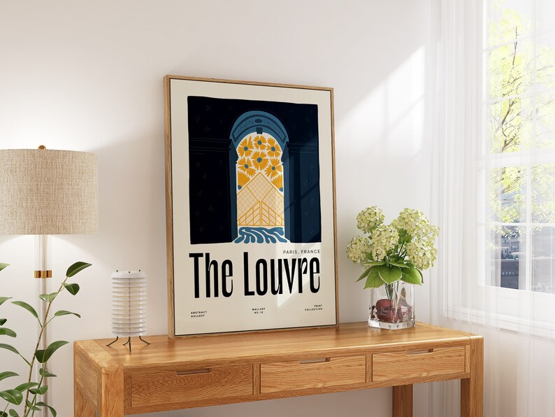 May include: A framed poster with a vintage design featuring a blue and yellow archway with the text "The Louvre" and "Paris, France".