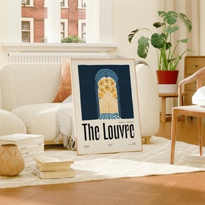 May include: A framed poster with a blue and yellow illustration of an archway with the text "The Louvre, Paris, France" printed below.