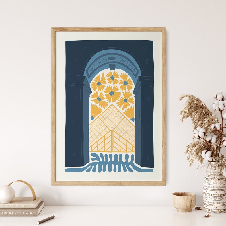 May include: A framed illustration of a blue archway with yellow flowers and a geometric pattern inside. The archway is set against a dark blue background.