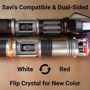 K&ouml;nnte beinhalten: Zwei doppelseitige Lichtschwerter mit dem Text "Savi's Compatible & Dual-Sided". Eines strahlt wei&szlig;es Licht aus, das andere rot. Der Text "Flip Crystal for New Color" ist ebenfalls sichtbar.
