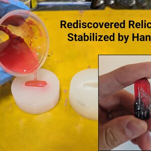 K&ouml;nnte beinhalten: Das Bild zeigt den Prozess der Stabilisierung eines Relikts. Rotes Harz wird in eine Form gegossen. Ein fertiges, stabilisiertes Relikt wird in der Hand gehalten. Der Text lautet "Rediscovered Relics - Stabilized by Hand".