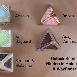 K&ouml;nnte beinhalten: Eine Auswahl an geometrischen Holocrons und Wegfindern in verschiedenen Farben. Die Sammlung umfasst W&uuml;rfel- und Pyramidenformen mit goldenen, silbernen, blauen, rosa, gr&uuml;nen und schwarzen Akzenten. Der Text auf dem Bild lautet "Ahsoka", "Dooku", "Krin Dagbard", "Asajj Ventress" und "Serenno & Malachor".