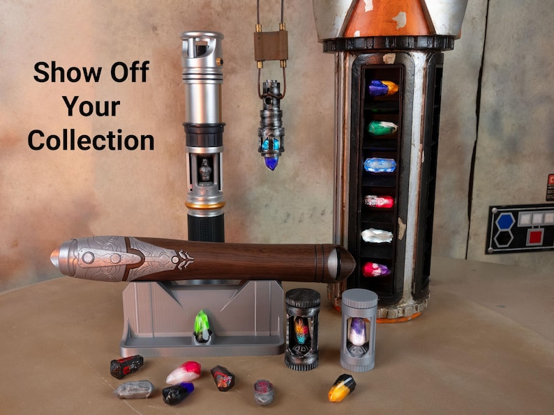 K&ouml;nnte beinhalten: Eine Sammlung von Lichtschwertern und Zubeh&ouml;r wird pr&auml;sentiert. Das Bild zeigt ein silbernes und schwarzes Lichtschwert, ein braunes und silbernes Lichtschwert und einen h&auml;ngenden Anh&auml;nger. Es gibt auch verschiedene farbige Kristalle und Beh&auml;lter mit dem Text "Show Off Your Collection".