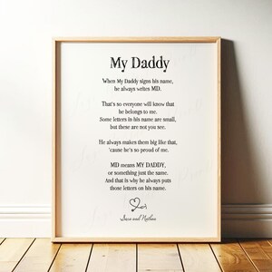 May include: A framed print with the text "My Daddy" in a black font. The poem describes a father's signature and love. The frame is a light brown color, and the background is white. The names "Sara and Nathan" are at the bottom.
