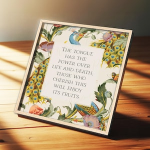 May include: Framed artwork with a light wood frame. The artwork features a floral and peacock feather design with the text: "THE TONGUE HAS THE POWER OVER LIFE AND DEATH; THOSE WHO CHERISH THIS WILL ENJOY ITS FRUITS."