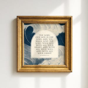 Könnte beinhalten: Quadratischer gerahmter Druck mit einem goldfarbenen Rahmen. Das Kunstwerk zeigt ein blau-weißes Wellenmuster mit Text in der Mitte. Der Text lautet: „DER HERR, UNSER GOTT, IST EIN HERR, UND DU SOLLST DEN HERRN, DEINEN GOTT, LIEBEN MIT DEINEM GANZEN HERZEN UND MIT DEINER GANZEN SEELE UND MIT ALL DEINER KRAFT.“