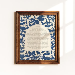 Könnte beinhalten: Ein gerahmter Wandkunstdruck mit einem dunkelblau-weißen Muster aus fliegenden Vögeln. Zentriert ist ein cremefarbenes, bogenförmiges Feld mit dem Text: CHRIST WITH ME, CHRIST BEFORE ME, CHRIST BEHIND ME, CHRIST IN ME, CHRIST BENEATH ME, CHRIST ABOVE ME.