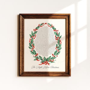 Pode incluir: Uma impressão emoldurada do poema "The Night Before Christmas". O texto está dentro de uma coroa de folhas verdes de azevinho e fitas vermelhas. A moldura é de madeira castanha escura.
