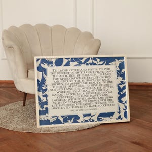 May include: A framed print featuring a quote by Ralph Waldo Emerson, with a blue and white bird design border. The text is in a classic serif font, set against a cream-colored background. The print is displayed near a beige armchair.
