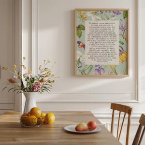 Print of Ralph Waldo Emerson Success poem written in a white center rectangle, surrounded by a background of light blue with vintage floral artwork. Pictured in a thin wood frame on the wall of a kitchen or breakfast room.
