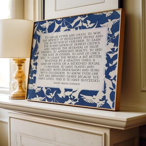 May include: A framed print with a wooden frame, featuring a blue and white bird pattern border. The print displays a quote by Ralph Waldo Emerson in a classic font. The artwork is displayed on a white mantelpiece.