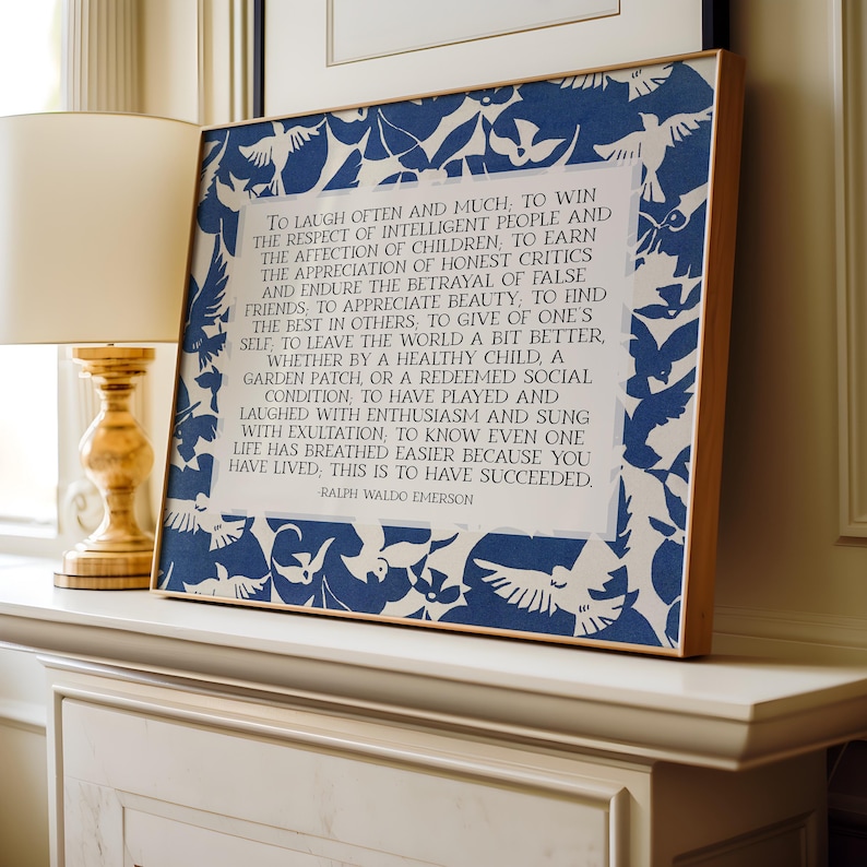 May include: A framed print with a wooden frame, featuring a blue and white bird pattern border. The print displays a quote by Ralph Waldo Emerson in a classic font. The artwork is displayed on a white mantelpiece.