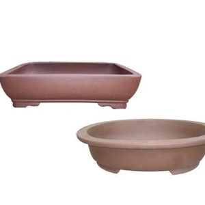 May include: Two terracotta bonsai pots, one rectangular and one oval. Both pots have a brown glaze and are unglazed on the bottom.
