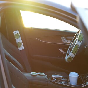 Green Monstera crochet car accessory set with steering wheel cover, seat belt cover and matching car coasters.