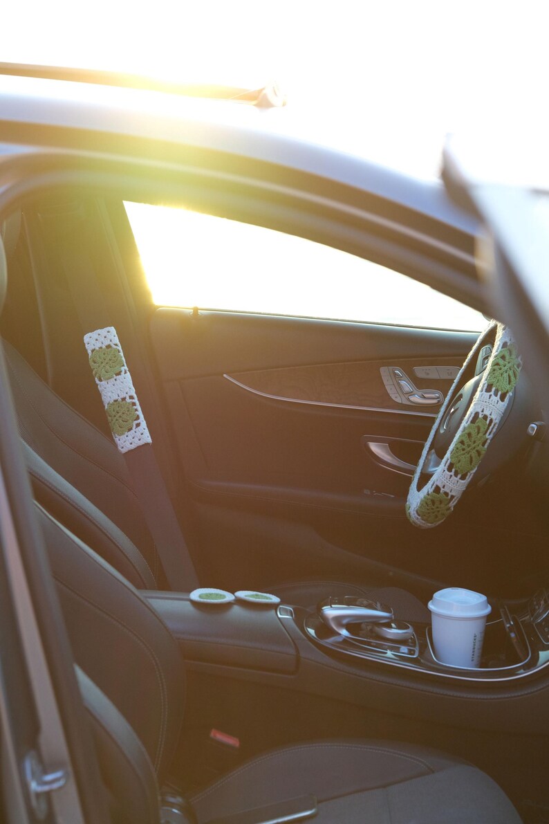 Green Monstera crochet car accessory set with steering wheel cover, seat belt cover and matching car coasters.