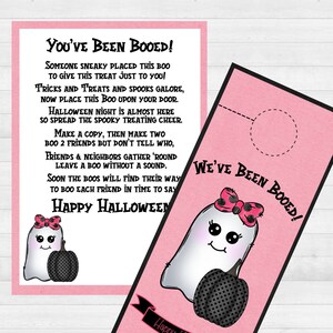 May include: A pink and white door hanger with a ghost holding a pumpkin. The text on the hanger reads "You've Been Booed!" and "We've Been Booed!" with a happy Halloween message at the bottom.