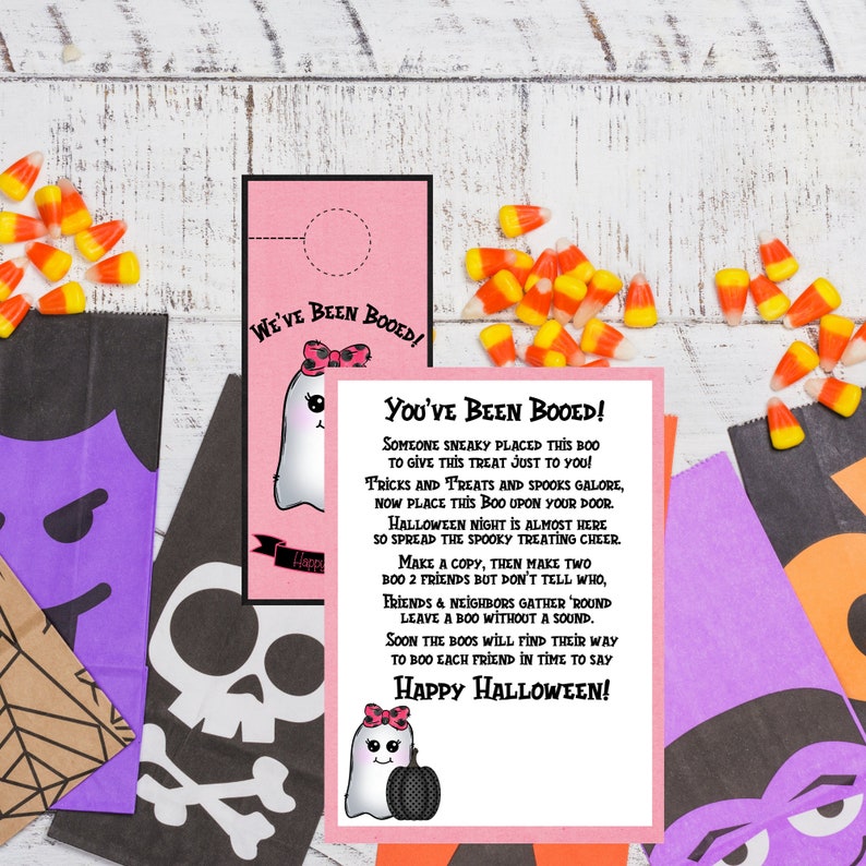 May include: A pink and white printable Halloween "You've Been Booed!" card with a ghost illustration and the text "Someone sneaky placed this boo to give this treat just to you! Tricks and treats and spooks galore, now place this boo upon your door. Halloween night is almost here so spread the spooky treating cheer. Make a copy, then make two boo 2 friends but don't tell who, friends & neighbors gather 'round leave a boo without a sound. Soon the boos will find their way to boo each friend in time to say Happy Halloween!"
