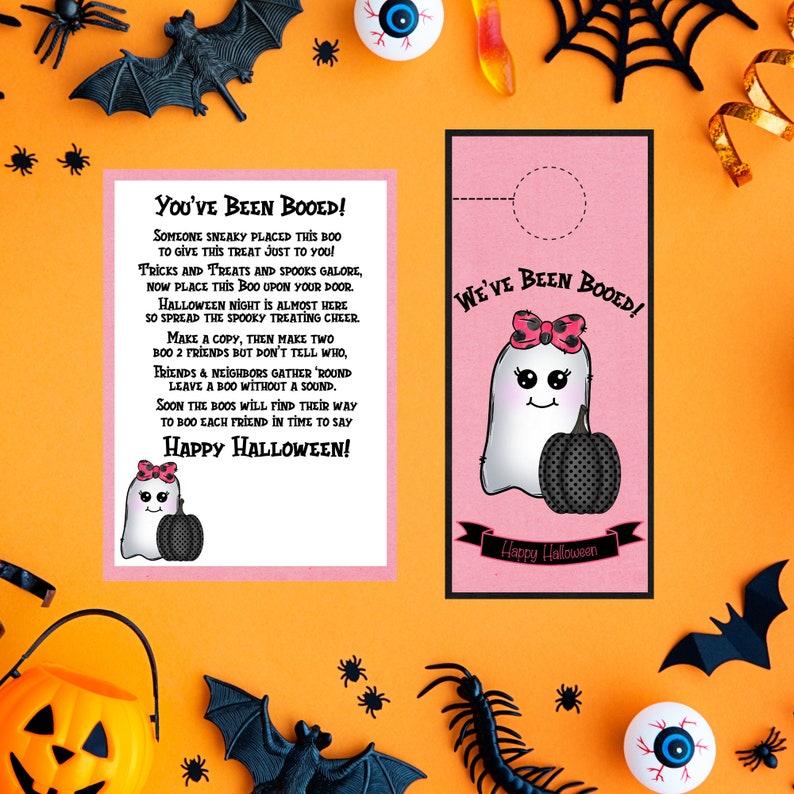 May include: A pink and white ghost with a pink bow and a black pumpkin holds a sign that says "We've Been Booed!"  The sign is attached to a door with a hole cut out for the sign.  The background is orange with black bats and spiders.