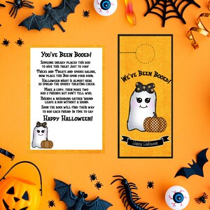 May include: Two printable Halloween door hangers featuring a cute ghost with a pumpkin. The text on the door hangers reads "You've Been Booed!" and "We've Been Booed!"