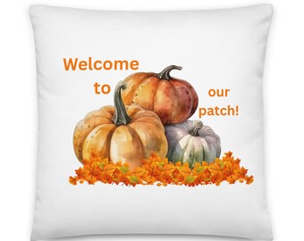 May include: White cushion with a watercolour design of three pumpkins in orange and green, with orange autumn leaves at the base. The text "Welcome to our patch!" is printed in orange.