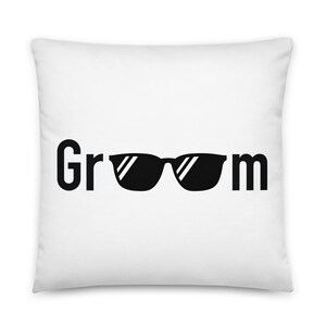 May include: White pillow with black text that reads "Groom" with sunglasses in between the words.
