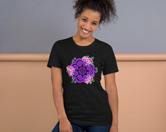 May include: Black t-shirt featuring a purple floral design with a central geometric pattern and colorful flowers. The design is centered on the front of the shirt. The shirt is made of a soft material.