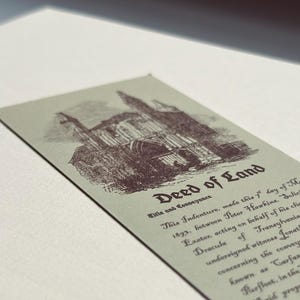 May include: A vintage-style Deed of Land document with an illustration of a building in dark red ink on a light green background. The text reads "Deed of Land" and includes details about the conveyance.