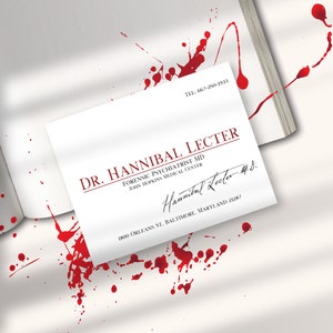K&ouml;nnte beinhalten: Eine wei&szlig;e Visitenkarte mit rotem Text f&uuml;r Dr. Hannibal Lecter, Forensischer Psychiater. Die Karte enth&auml;lt die Adresse des John Hopkins Medical Center und eine Unterschrift. Rote Spritzer umgeben die Karte und ein Buch.