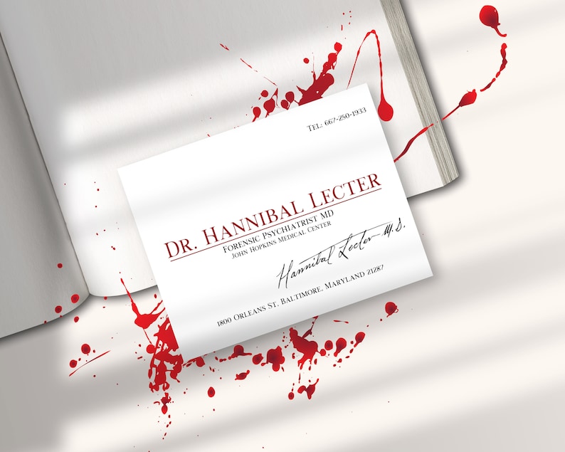 K&ouml;nnte beinhalten: Eine wei&szlig;e Visitenkarte mit rotem Text f&uuml;r Dr. Hannibal Lecter, Forensischer Psychiater. Die Karte enth&auml;lt die Adresse des John Hopkins Medical Center und eine Unterschrift. Rote Spritzer umgeben die Karte und ein Buch.