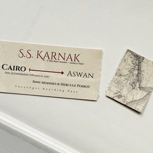 K&ouml;nnte beinhalten: Ein Vintage-Bordkarte f&uuml;r das S.S. Karnak Nil-Flussdampfer, mit der Route von Kairo nach Assuan. Der Pass enth&auml;lt das Einschiffungsdatum, 12. Februar 1937, und den Namen MONSIEUR HERCULE POIROT. Eine kleine Karte ist ebenfalls vorhanden.