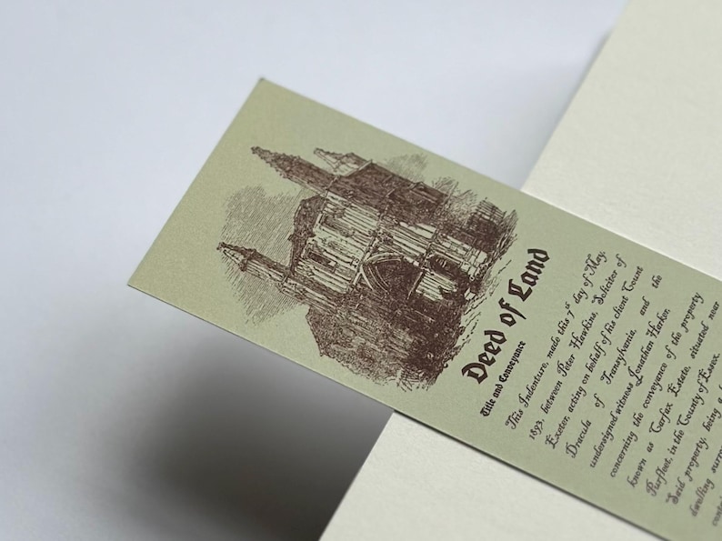 May include: A vintage-style bookmark with the title "Deed of Land" in a serif font. The bookmark features an illustration of a castle in brown ink on a light green background. Text details the conveyance.